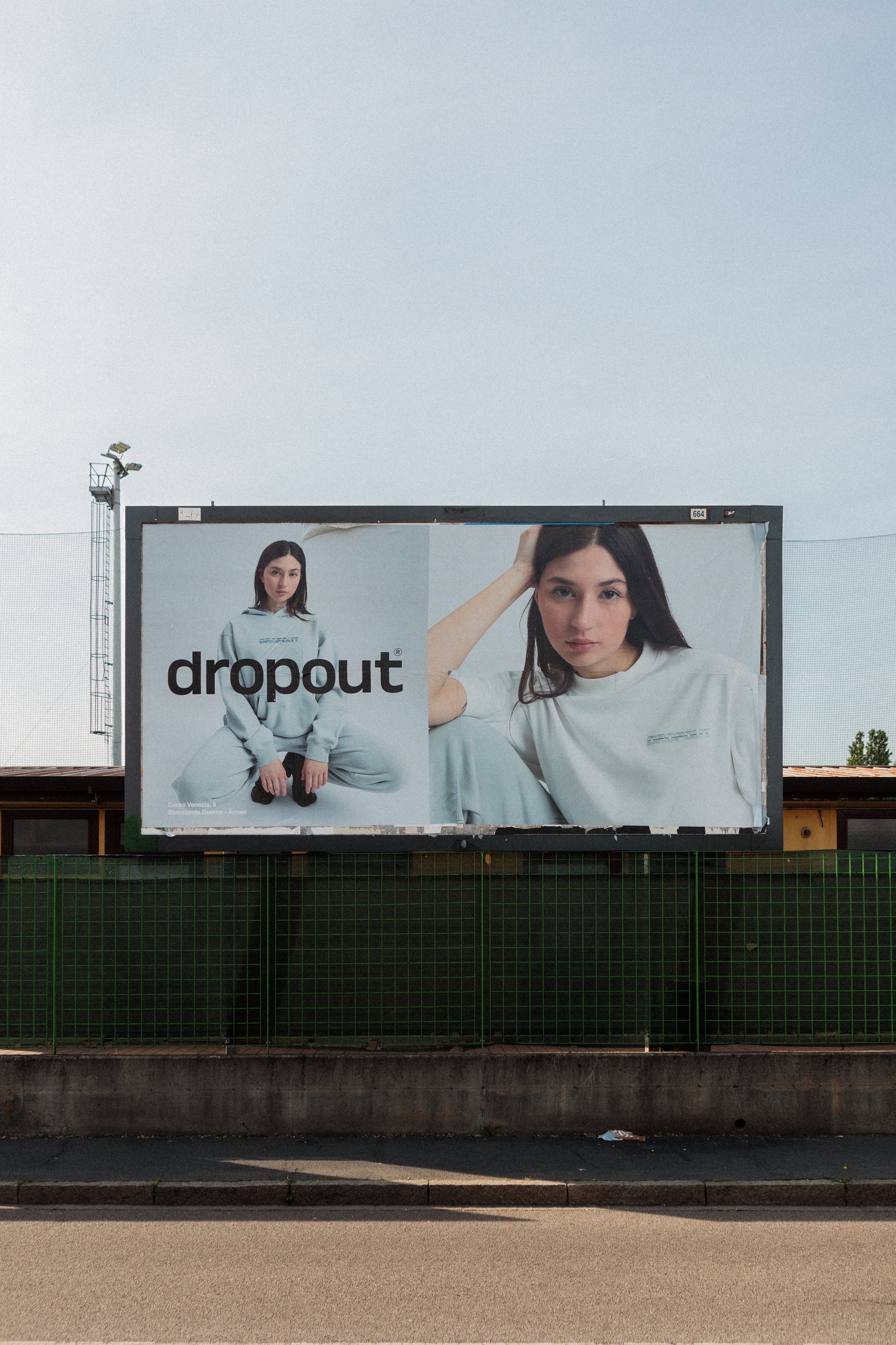 Billboard featuring a model in casual attire with the word 'dropout' prominently displayed.