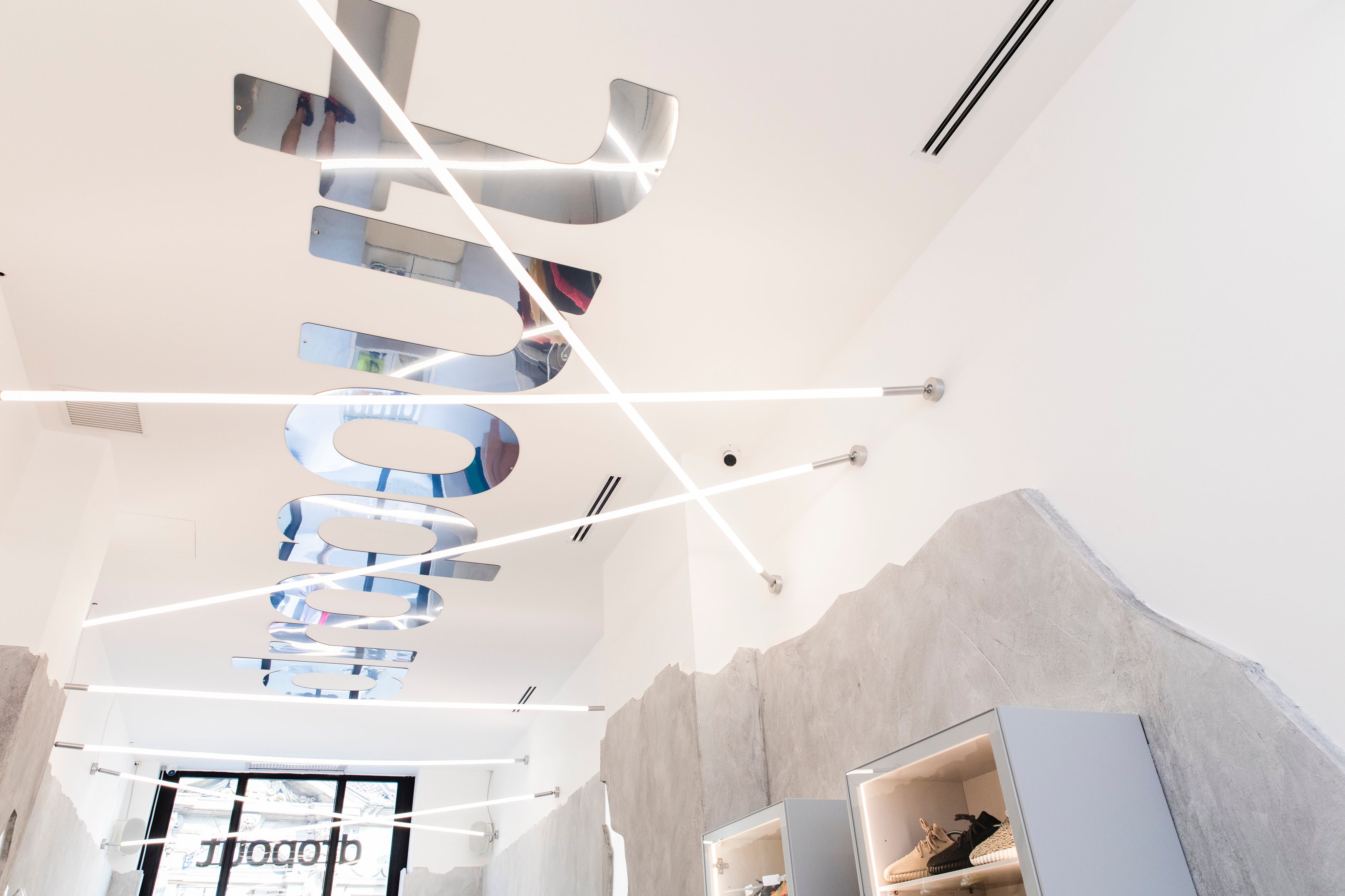 Modern retail store interior with mirrored signage and sleek lighting design.