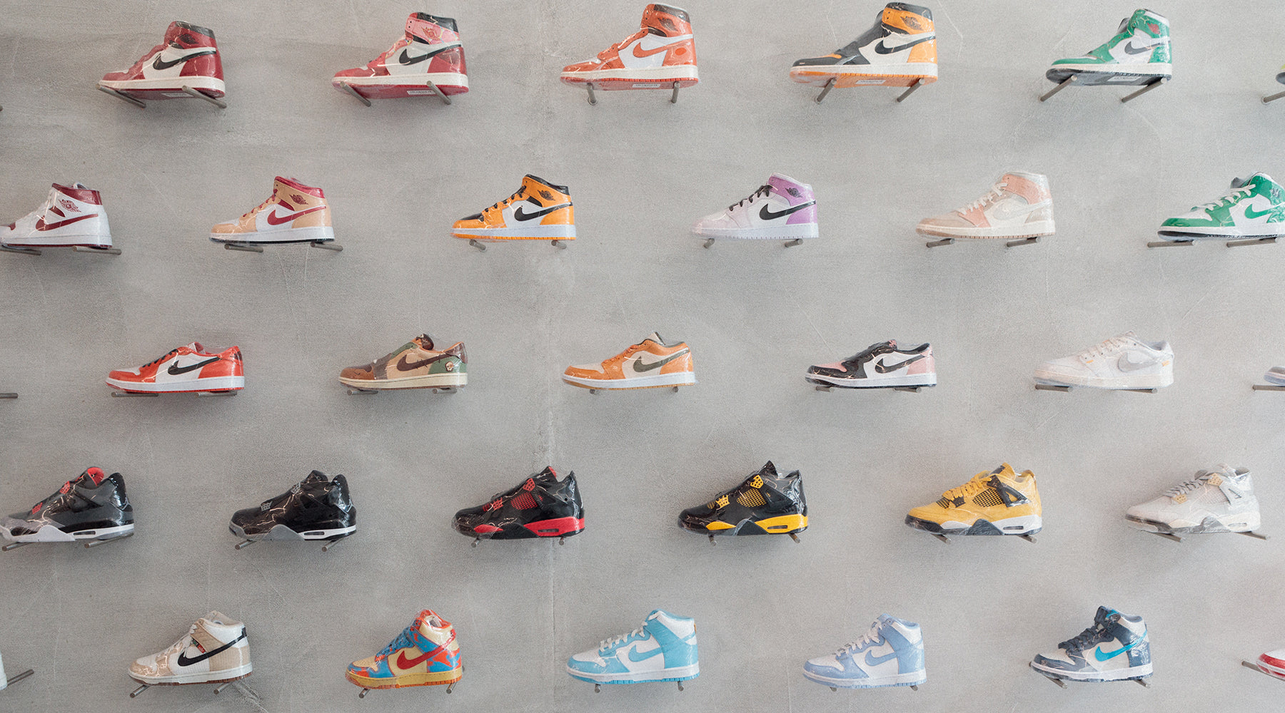A stylish display of various Nike sneakers arranged on a wall, showcasing different colors and designs.