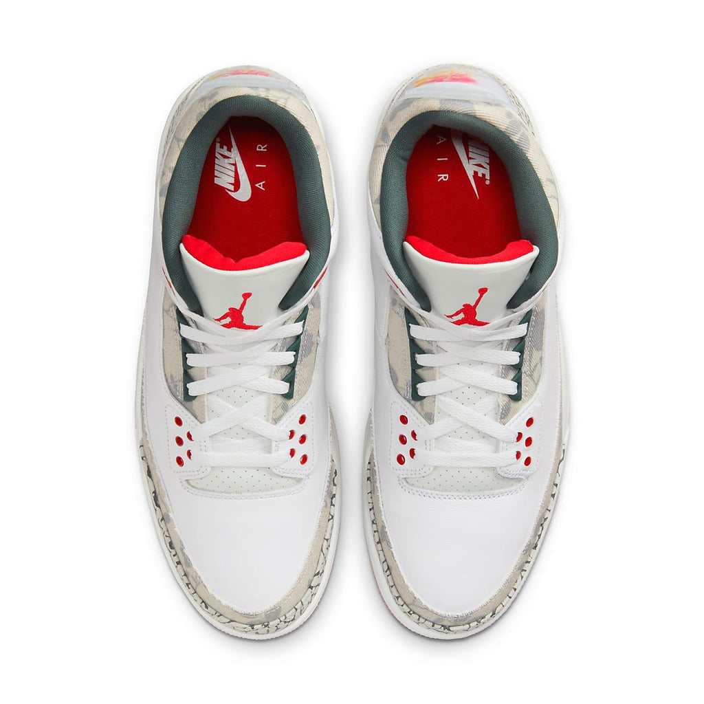 Top view of Air Jordan 3 Retro 'Wings' shoes featuring white leather, elephant print, and red accents.