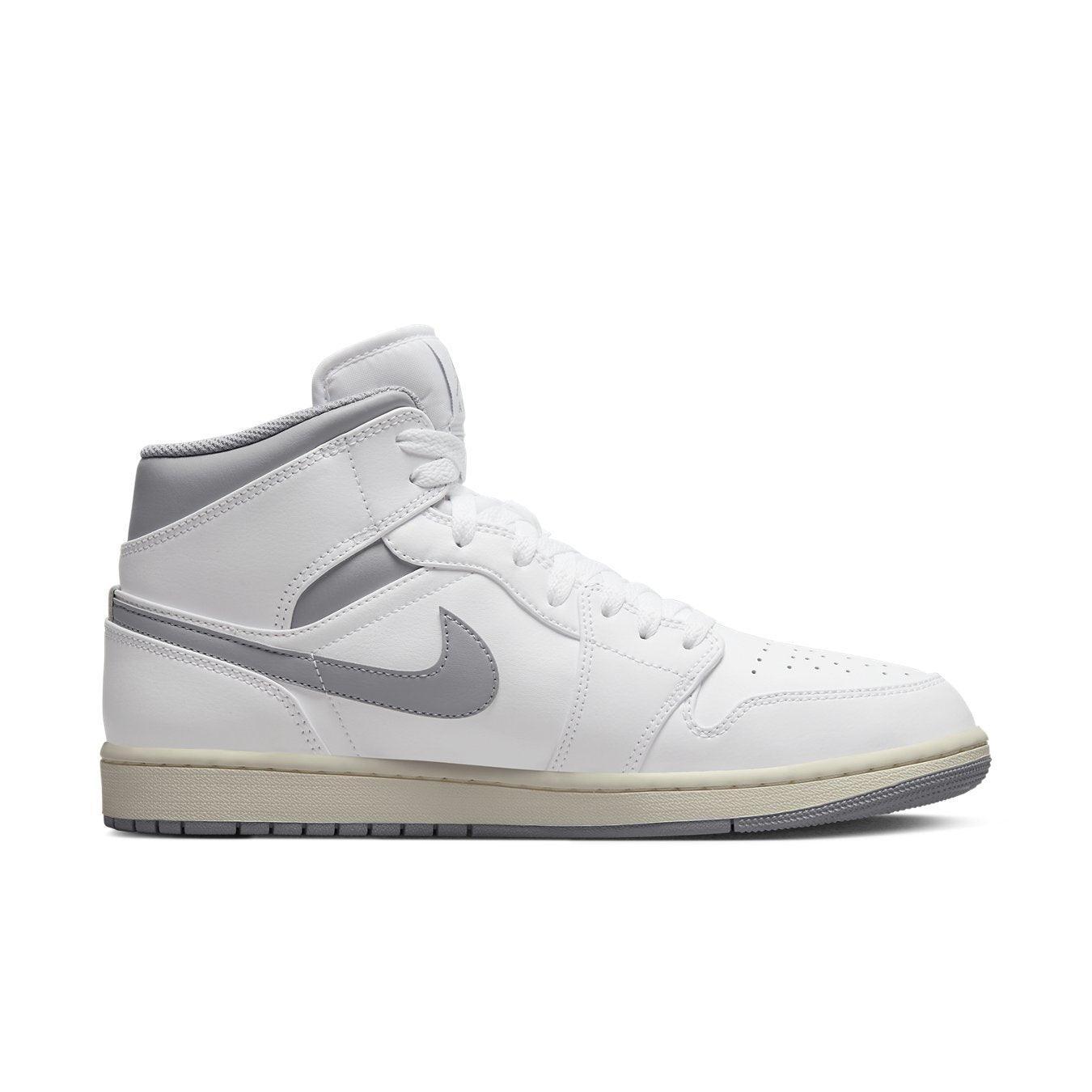 Air Jordan 1 Mid Neutral Grey in white leather with grey Swoosh and collar, showcasing a sleek basketball silhouette.