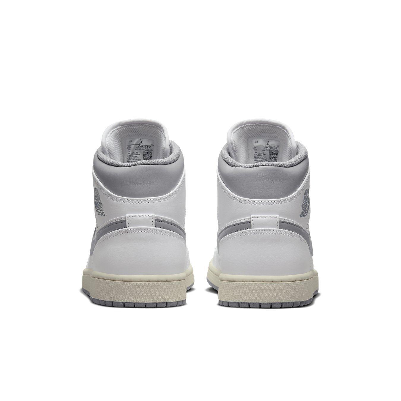 Air Jordan 1 Mid Neutral Grey sneakers rear view, featuring white leather and subtle grey detailing.