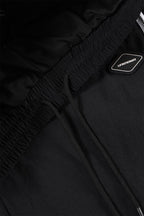 Close-up of the waistband and logo on Black/White NPT Baby Gang Zip Track Pants.