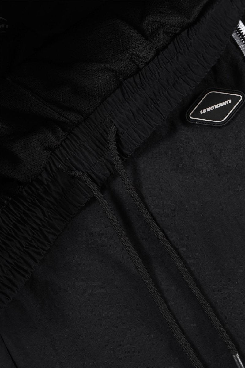 Close-up of the waistband and logo on Black/White NPT Baby Gang Zip Track Pants.