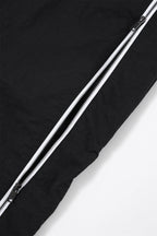 Close-up of the zipper detail on Black/White NPT Baby Gang zip track pants, showcasing fabric texture.