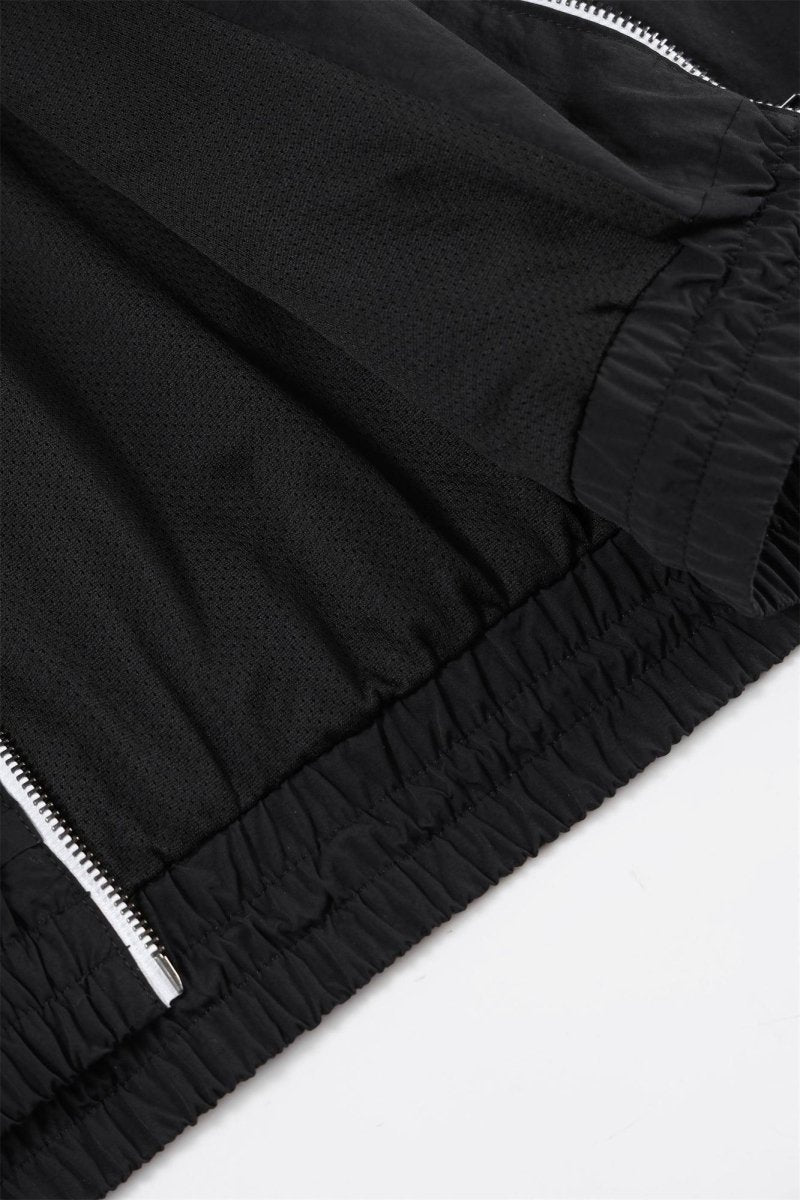 Close-up of the Black/White NPT Baby Gang Zip Track Top, showcasing its sleek black fabric and zipper details.