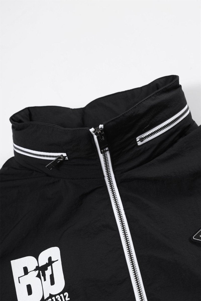 Close-up of a black zip track top with white accents, featuring the Baby Gang logo and stylish collar design.