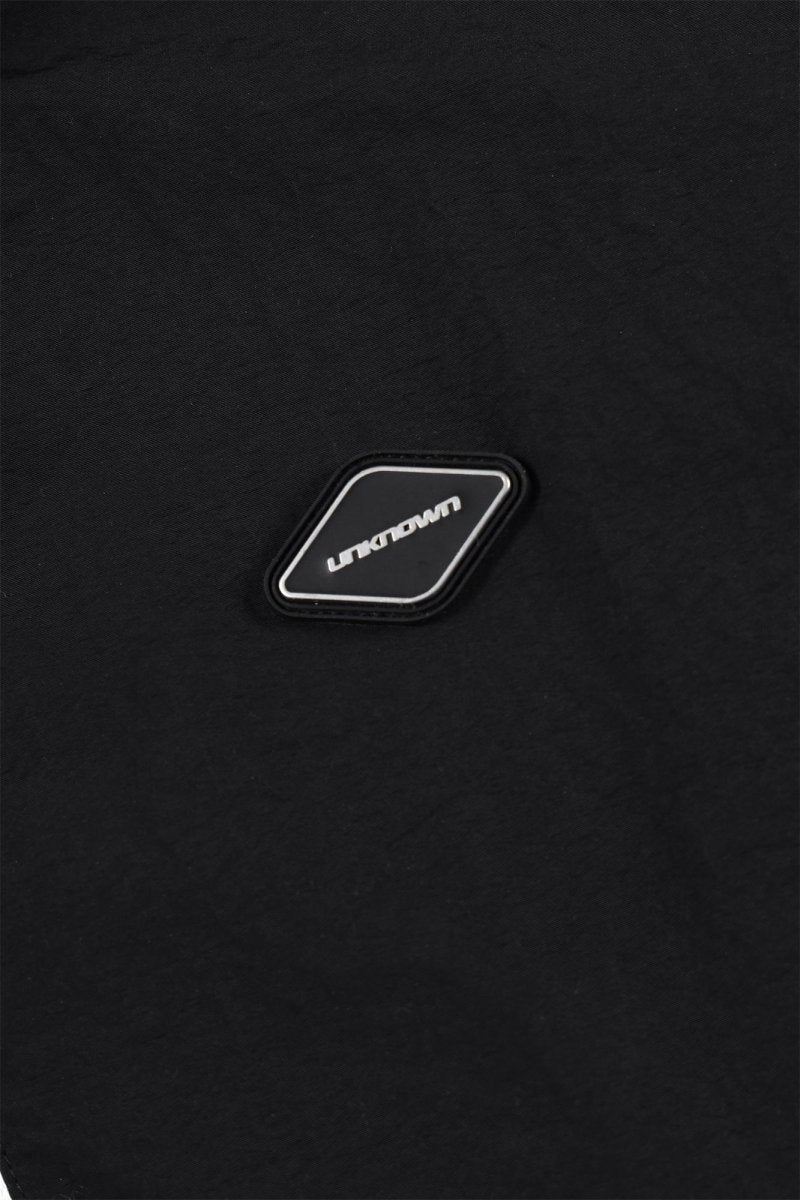 Detail of Black NPT Baby Gang Zip Track Top showing the logo patch on the fabric in a close-up view.