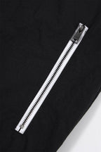 Close-up of the zip detail on the Black/White NPT Baby Gang Zip Track Top, showcasing a sleek black fabric and white zipper.