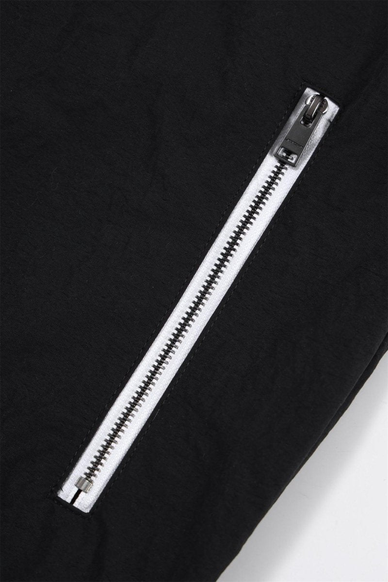 Close-up of the zip detail on the Black/White NPT Baby Gang Zip Track Top, showcasing a sleek black fabric and white zipper.