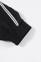 Close-up of the cuff of the Black/White NPT Baby Gang Zip Track Top showing elastic and zipper detailing.