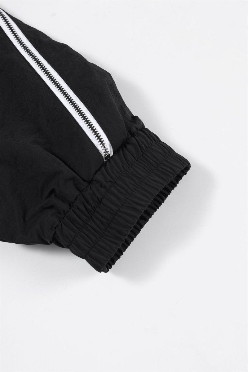 Close-up of the cuff of the Black/White NPT Baby Gang Zip Track Top showing elastic and zipper detailing.
