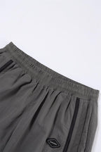 Grey and black NPT Simba La Rue zip track pants with elastic waistband and side pockets, showcasing casual athletic style.