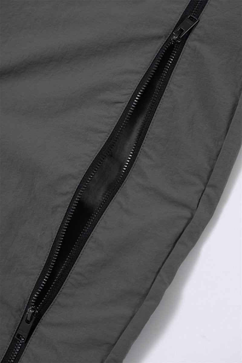 Close-up of the grey and black zip detailing on NPT Simba La Rue track pants, showcasing high-quality fabric and design.