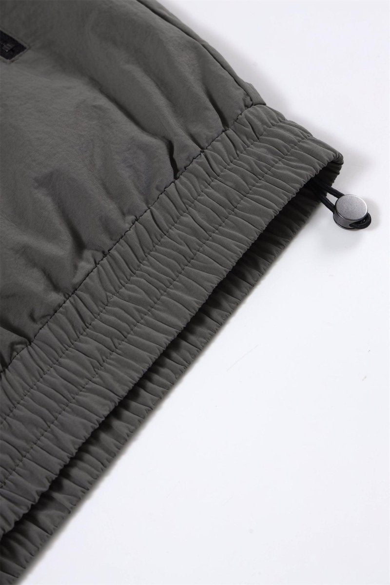 Close-up of the grey/black NPT Simba La Rue zip track top showcasing the elastic hem and drawstring detail.