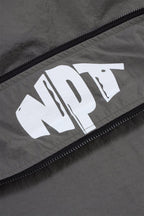 Close-up of the NPT logo on the grey and black Simba La Rue zip track top.