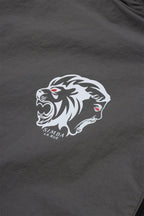 Close-up of the grey and black Simba La Rue lion logo on a zip track top, showcasing bold design and intricate details.