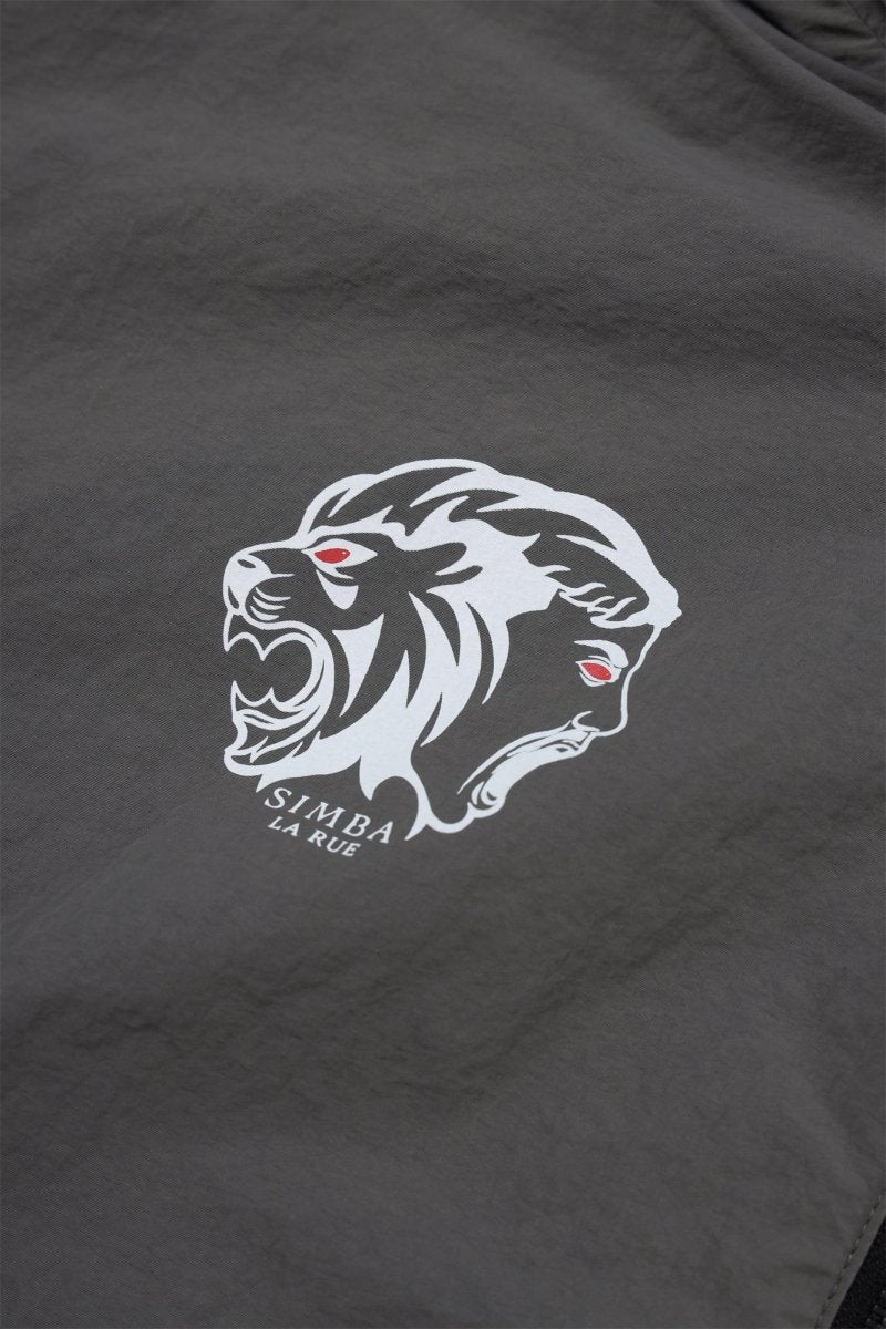 Close-up of the grey and black Simba La Rue lion logo on a zip track top, showcasing bold design and intricate details.