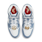 Air Jordan 1 High OG Denim (W) featuring a denim upper, white leather, and unique gold accessories.