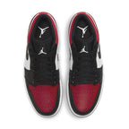 Top view of Jordan 1 Low "Bred Toe" sneakers featuring black and red leather design with white accents.