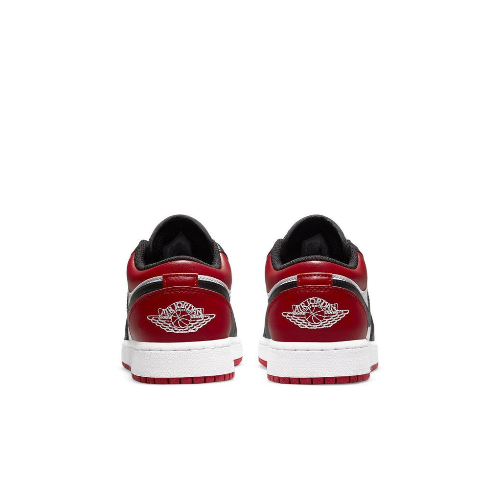 Back view of Jordan 1 Low Bred Toe (GS) sneakers featuring red and black leather with white midsole.