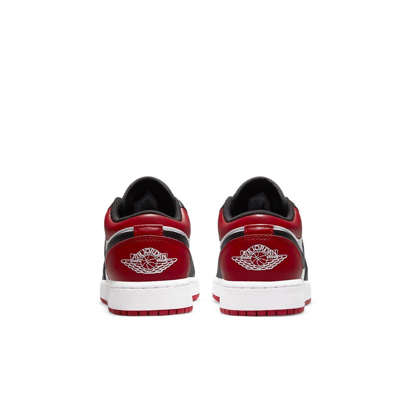 Back view of Jordan 1 Low Bred Toe (GS) sneakers featuring red and black leather with white midsole.