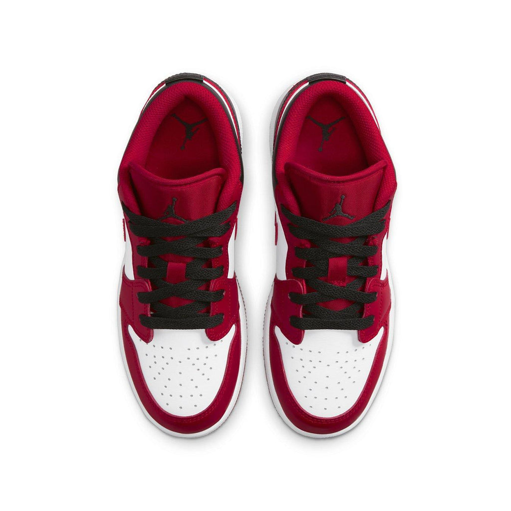 Air Jordan 1 Low Bulls GS sneakers in white and Gym Red, featuring black laces, top view.