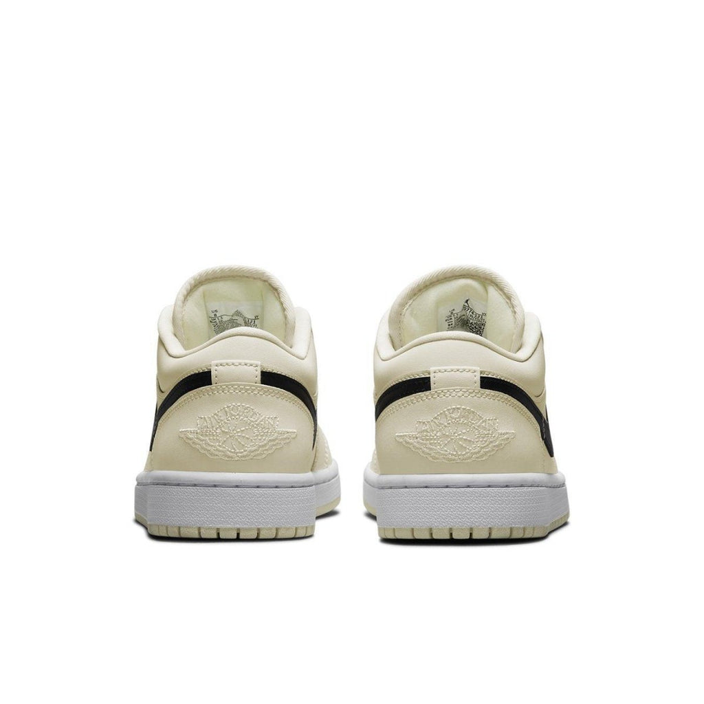 Retro Air Jordan 1 Low Coconut Milk sneaker in cream color with black accents and iconic logo on heel.