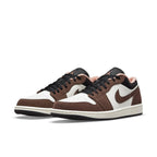 Jordan 1 Low Mocha sneakers in brown suede and white leather, featuring black accents and pink details.