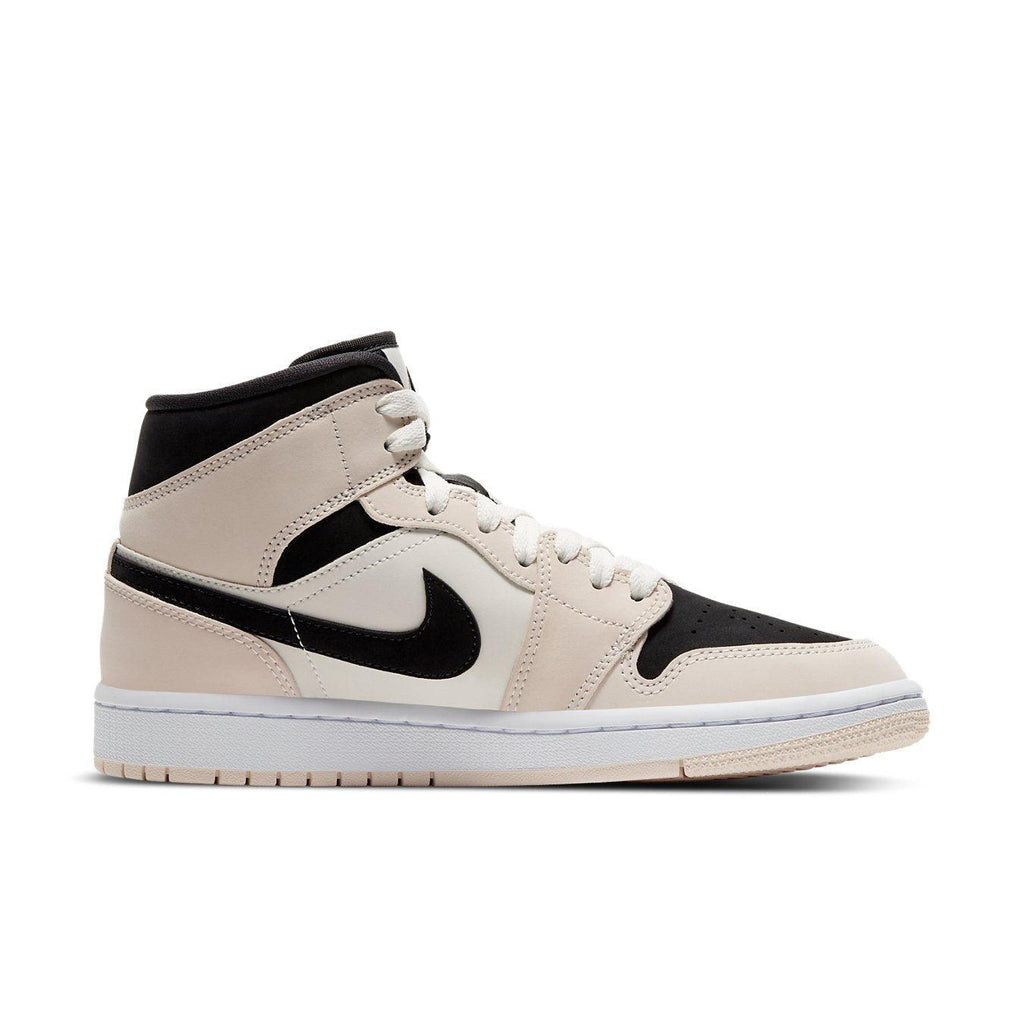 Air Jordan 1 Mid Barely Orange (W) in leather with white, black accents and soft orange laces, featuring a bicolored sole.