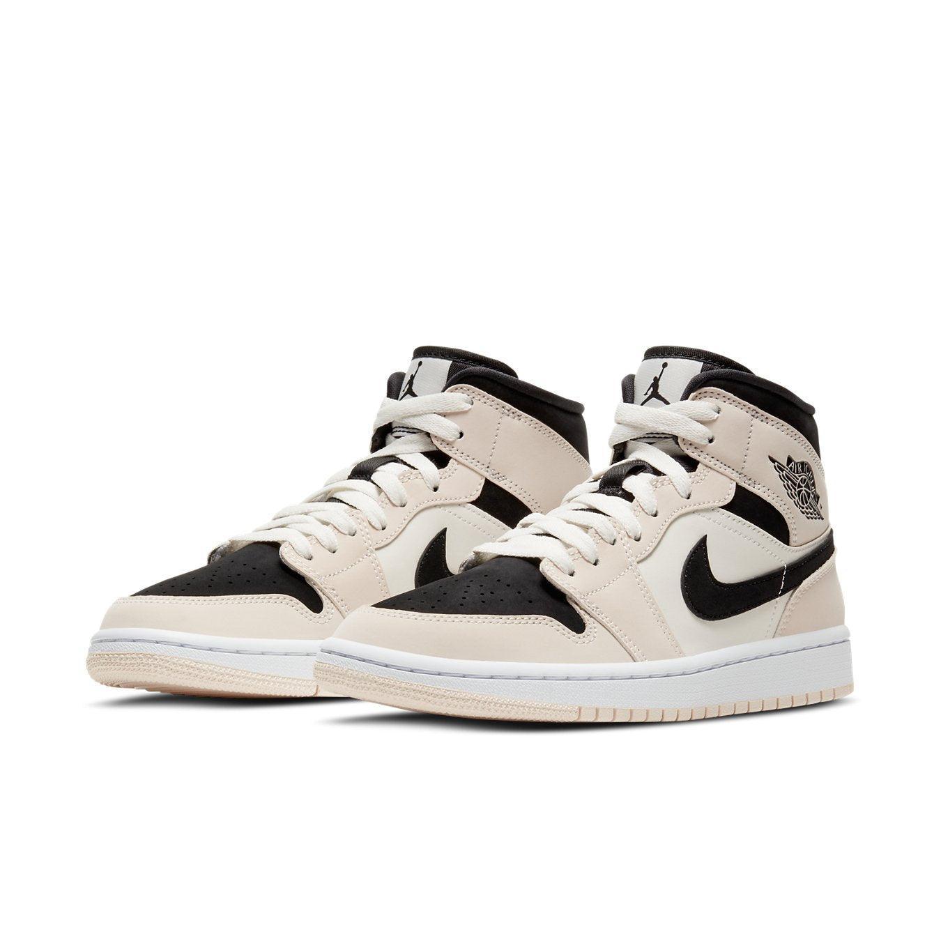 Air Jordan 1 Mid Barely Orange sneakers in cream and black design with white accents and soft orange laces.