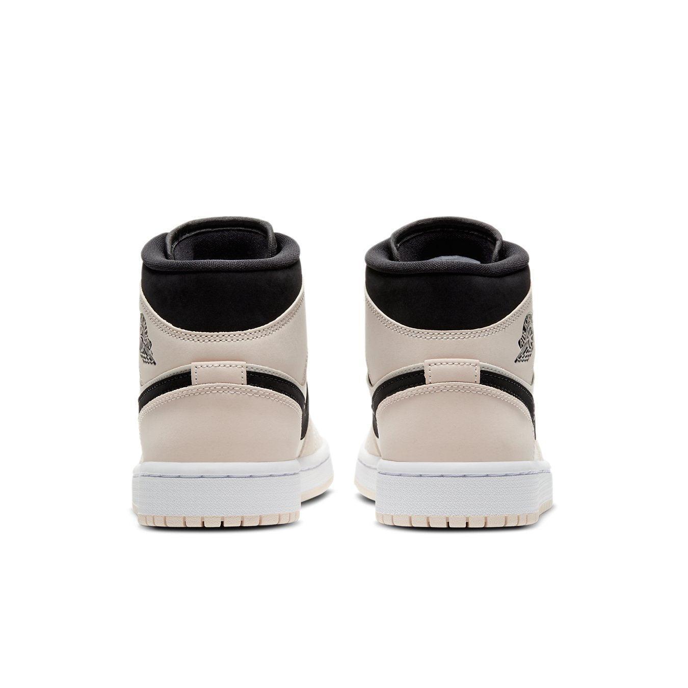 Rear view of Jordan 1 Mid Barely Orange women's sneakers showcasing the black and soft peach design with iconic branding.