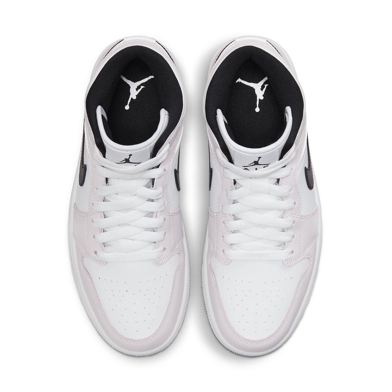 Top view of Air Jordan 1 Mid Barely Rose women's sneakers in white and black with iconic Jordan logo.