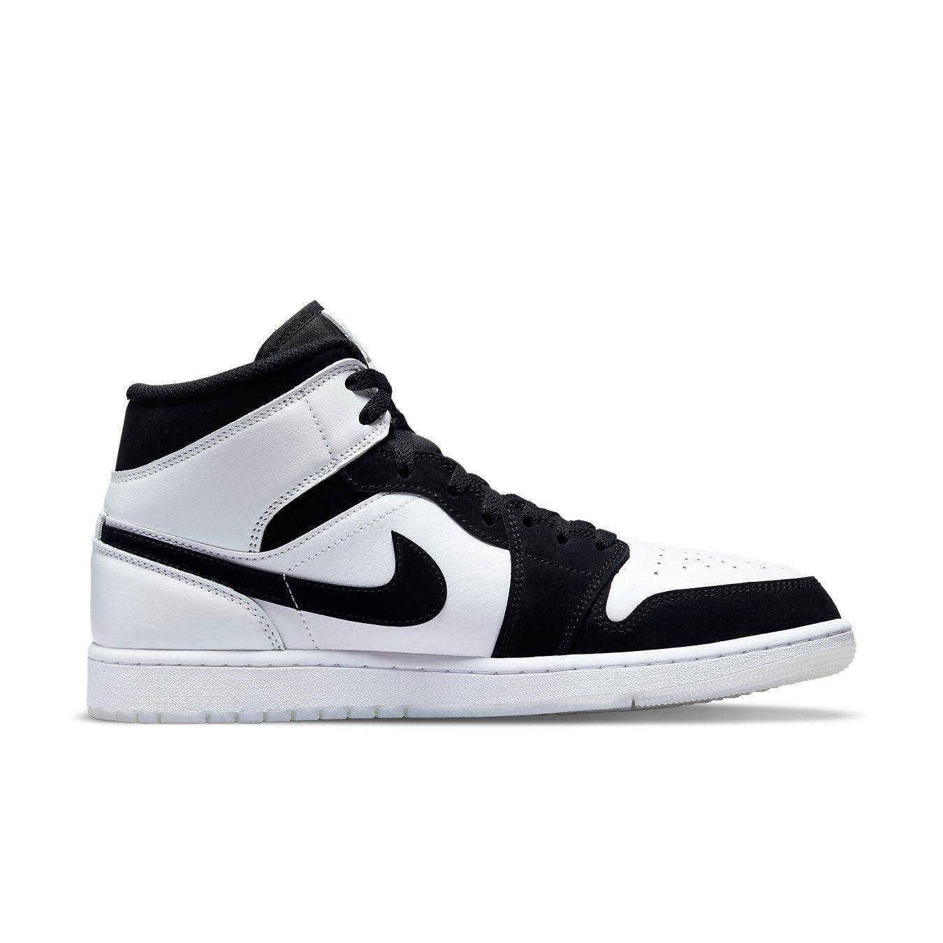 Nike Air Jordan 1 Mid in black and white, featuring leather upper and iconic Swoosh design.