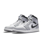 Jordan 1 Mid Light Smoke Grey Anthracite sneakers, featuring a leather upper in grey and white with Nike Swoosh and cushioning.