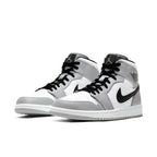 Air Jordan 1 Mid Light Smoke Grey sneakers, featuring a stylish grey and white design with black accents.