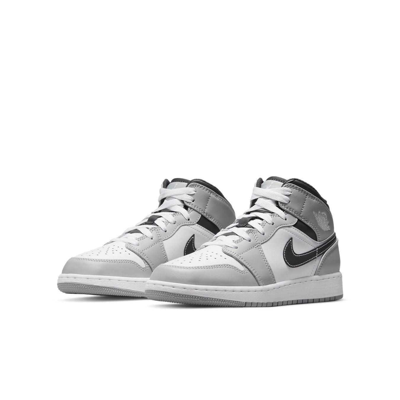 Air Jordan 1 Mid Light Smoke Grey shoes with grey and white leather, featuring a black Swoosh and modern design.