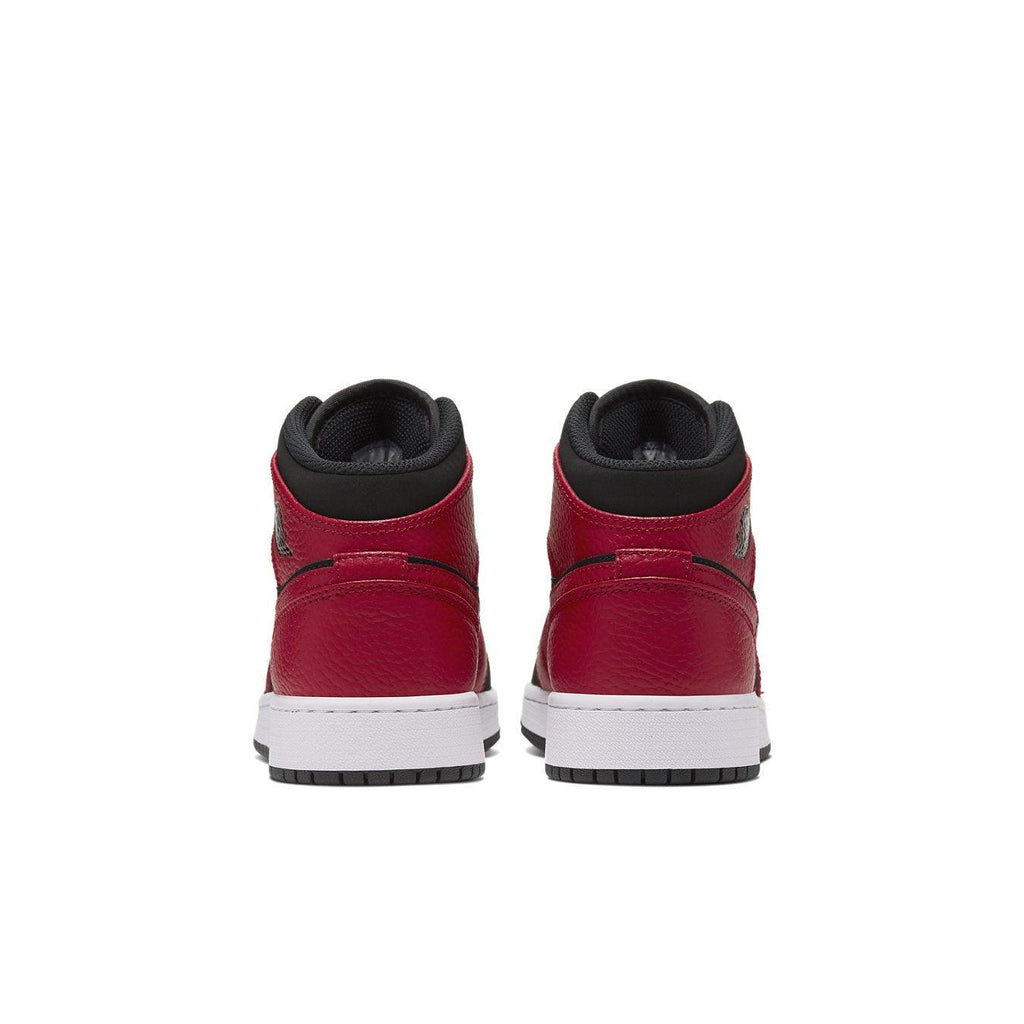 Air Jordan 1 Mid Reverse Bred (GS) shoes rear view showcasing red leather and black accents.