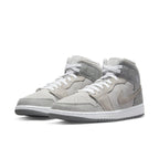 Jordan 1 Mid SE Particle Grey sneakers featuring smooth synthetic leather and suede overlays in gray.