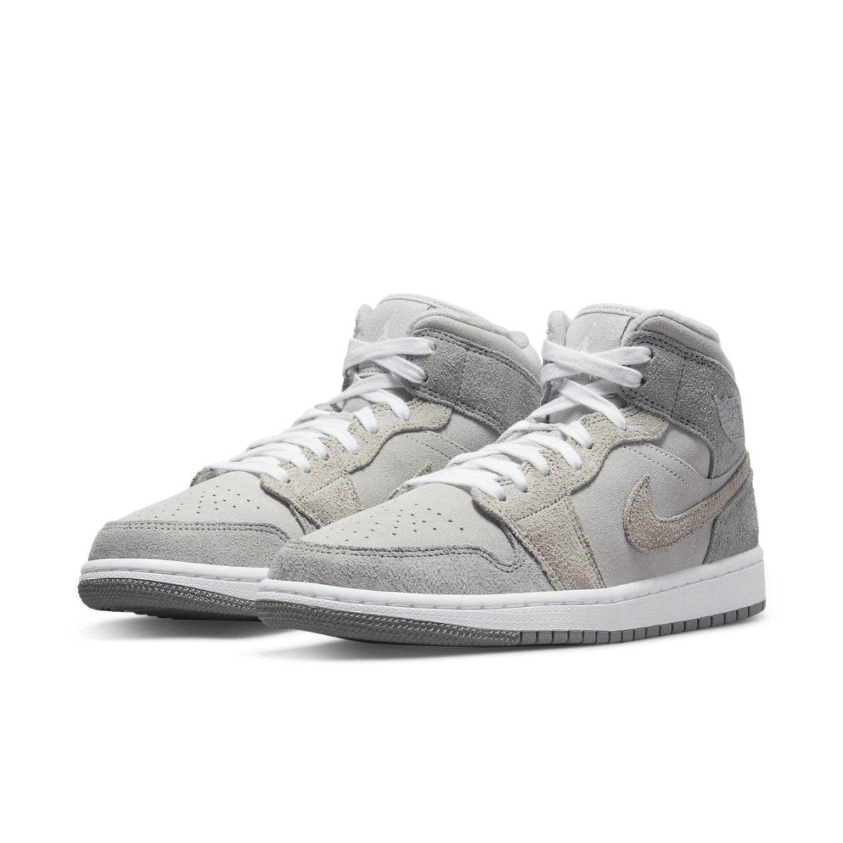 Jordan 1 Mid SE Particle Grey sneakers featuring smooth synthetic leather and suede overlays in gray.
