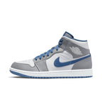 Air Jordan 1 Mid True Blue with white leather upper and blue accents on Swoosh and collar, model side view.
