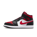 Jordan 1 Mid in white, black, and red with unique oversized nylon tongue and perforated toe design.