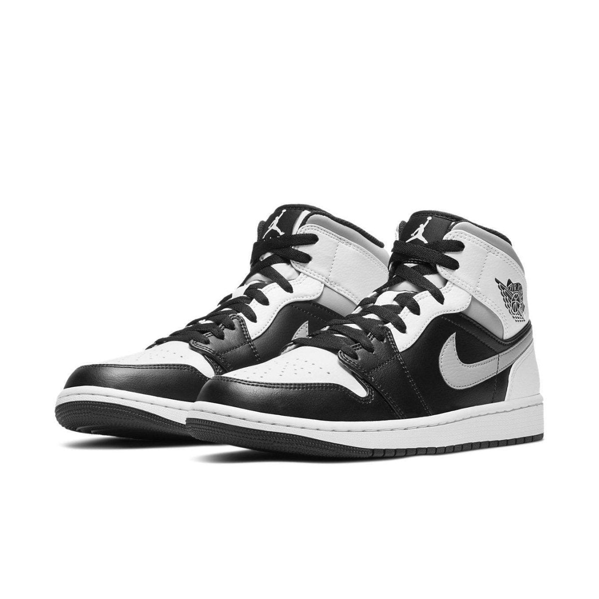 Air Jordan 1 Mid White Shadow in black and white leather with Nike swoosh, featuring black laces and classic design.