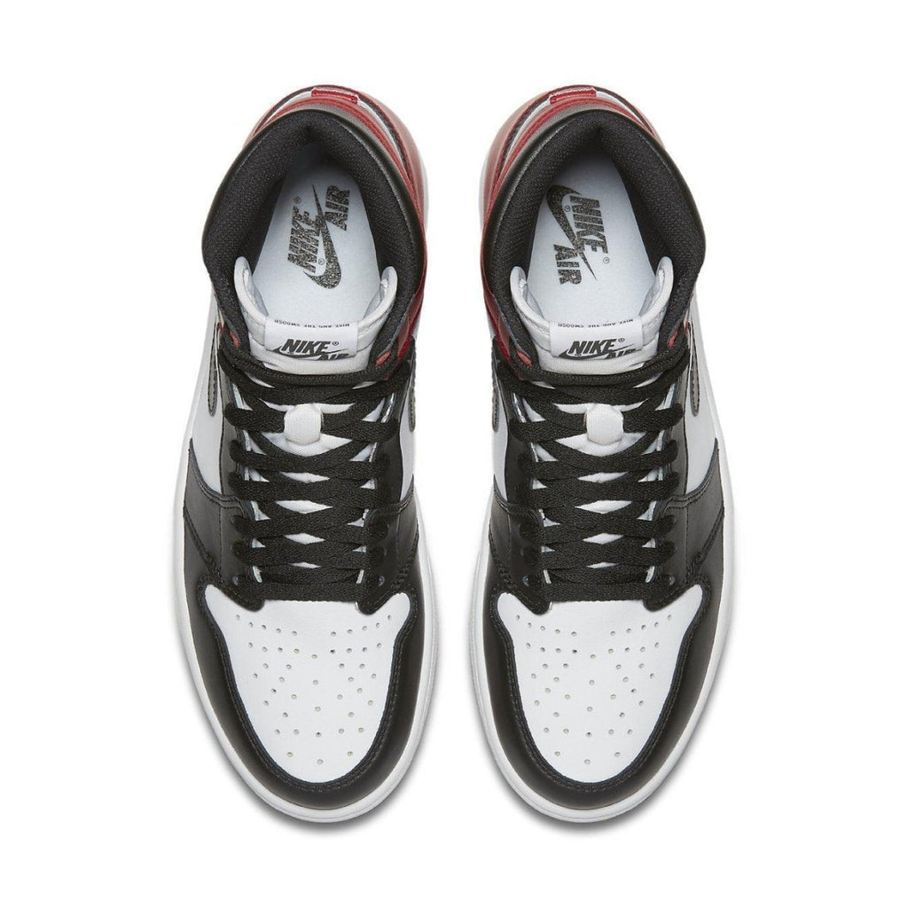 Top view of Jordan 1 Retro Black Toe sneakers with black and white leather, red accents, and signature Nike branding.