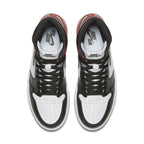 Top view of Jordan 1 Retro Black Toe sneakers with black and white leather, red accents, and signature Nike branding.
