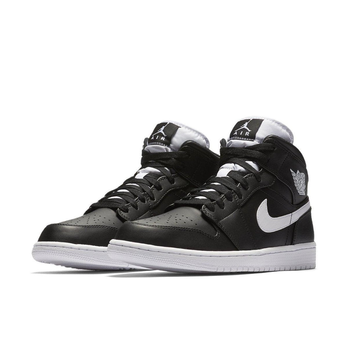 Air Jordan 1 Retro Mid Black White sneakers with leather upper, nylon tongue, and embroidered Jumpman logo.