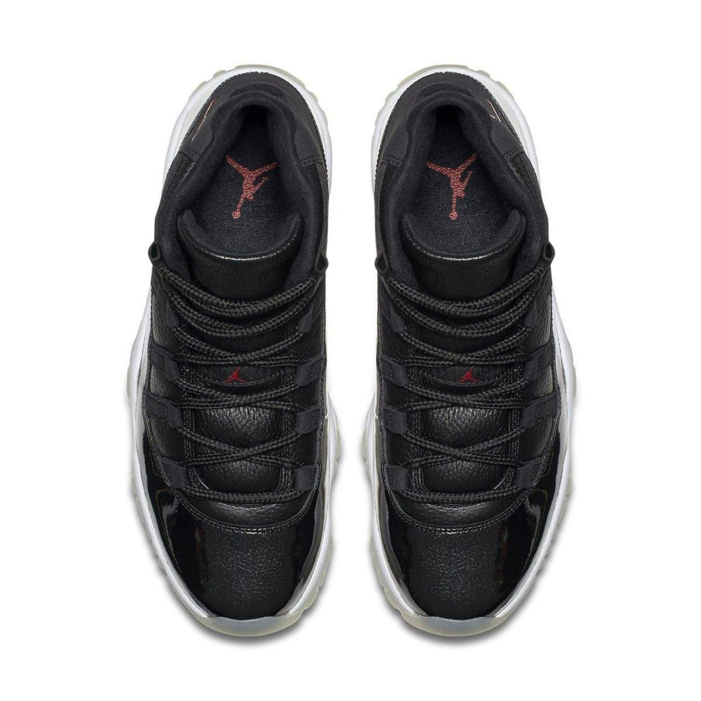 Top view of Air Jordan 11 Retro '72-10' sneakers featuring premium black leather and sleek design.