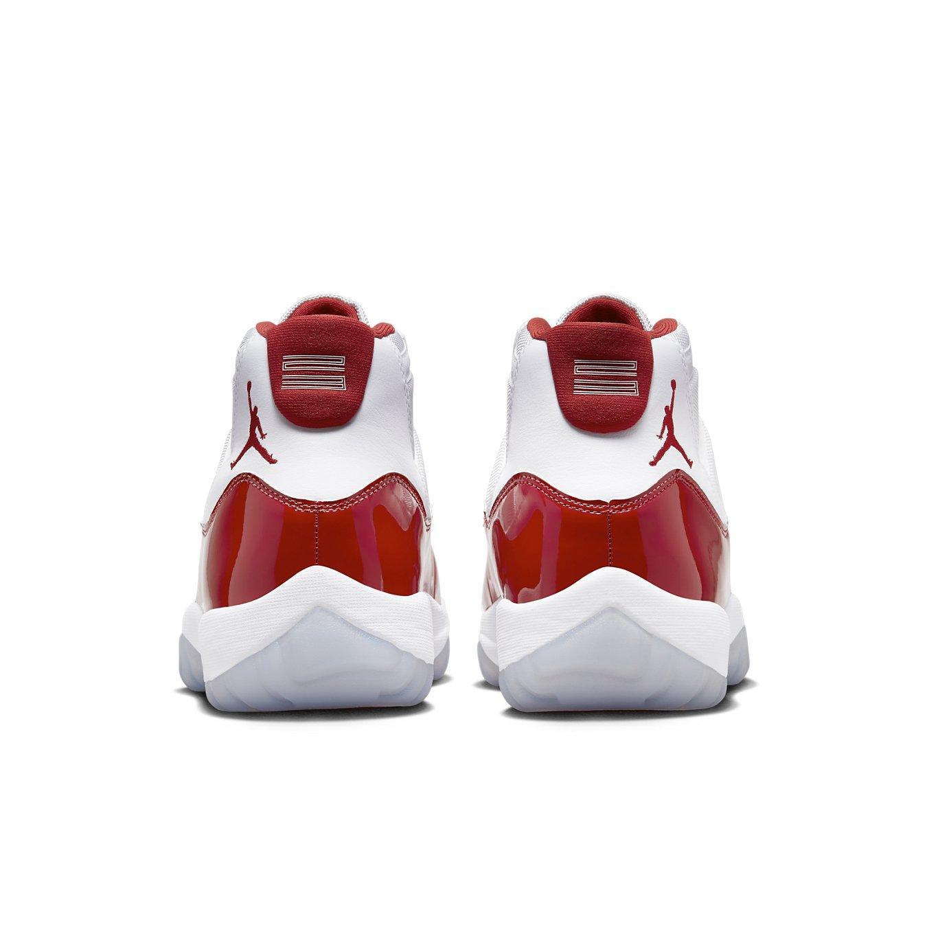 Rear view of Jordan 11 Retro 'Cherry' sneakers featuring a white upper and scarlet patent leather accents.