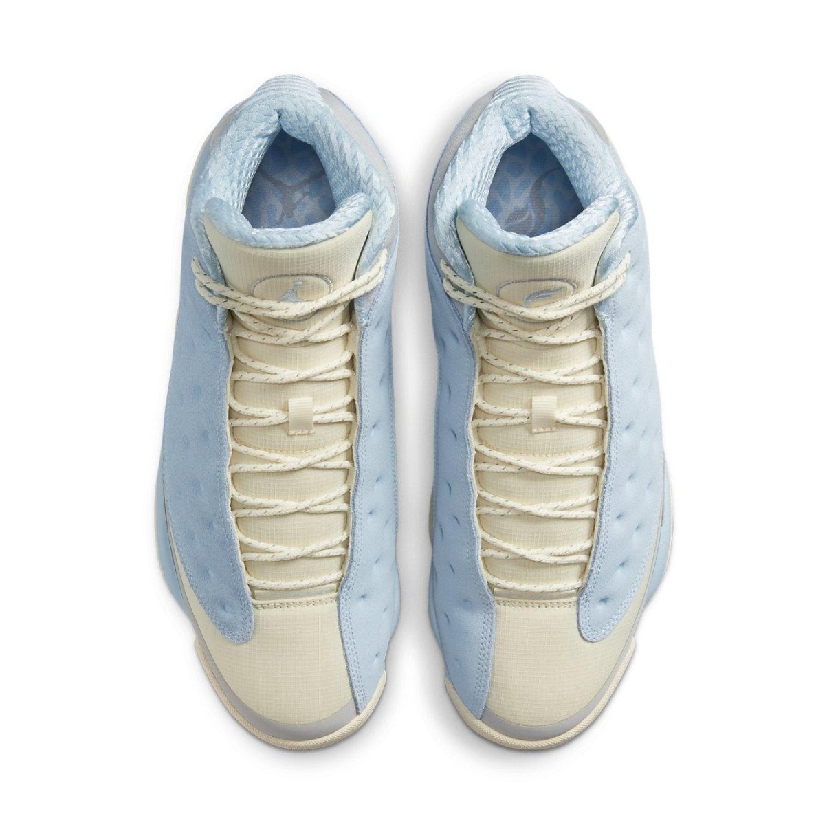 Air Jordan 13 Retro SoleFly in light blue and cream colorway with unique textures and laces from overhead view.
