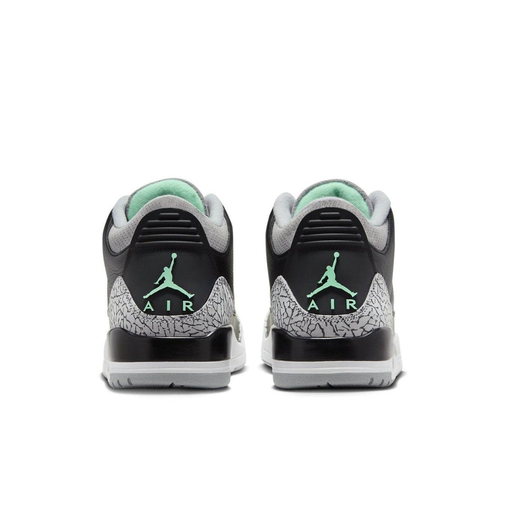 Rear view of Jordan 3 Retro Green Glow sneakers showcasing black leather and green accents.